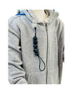 the black Chewy Charms Chewy Loop Shirt Saver - Clip On attached to a grey jumper on a minikin