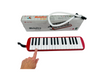 a hand touching the 32 Key Melodica outside of it&#39;s box