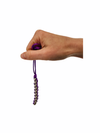 a hand holding the purple Kaiko silver Caterpillar Necklace