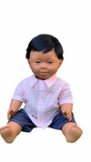 Down Syndrome Doll - Mid Skin/Dark Hair Boy in sitting position wearing shirt on white background