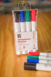 EC Whiteboard Markers in pastic storage wallet with pens placed on wooden table