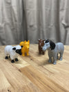 the animals from the Magnetic Mix or Match - Farm Animals set on woode table and grew background